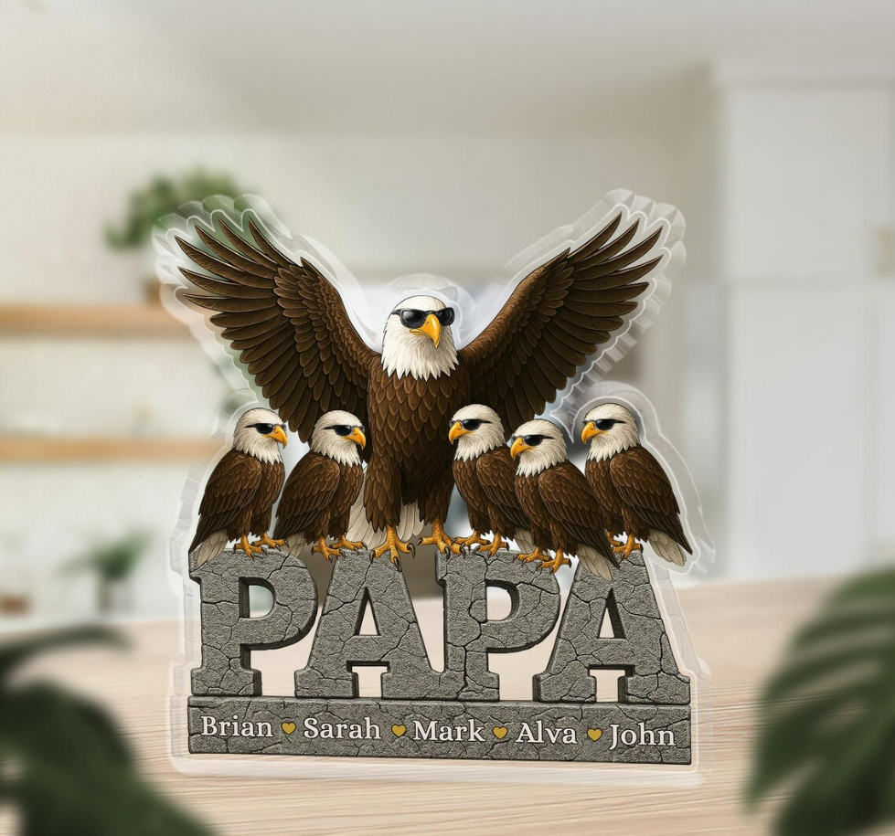 Decorative sign with an eagle and chicks spelling 'PAPA' on a blurred background