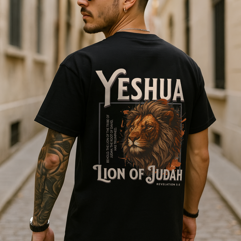 Man wearing black Yeshua Lion of Judah shirt with bold lion graphic and Bible verse on back, urban background