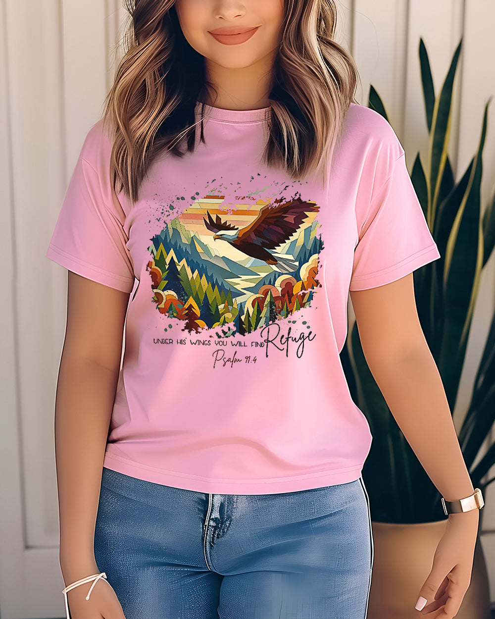 Blossom pink Comfort Colors tee with Psalm 91:4 quote and eagle over colorful mountains. Worn by woman with soft waves and jeans.
