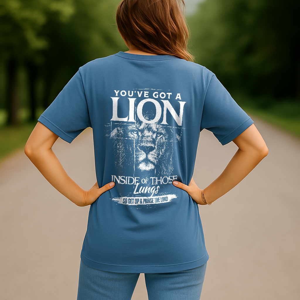 Woman in blue Comfort Colors shirt with “Praise the Lord” lion design