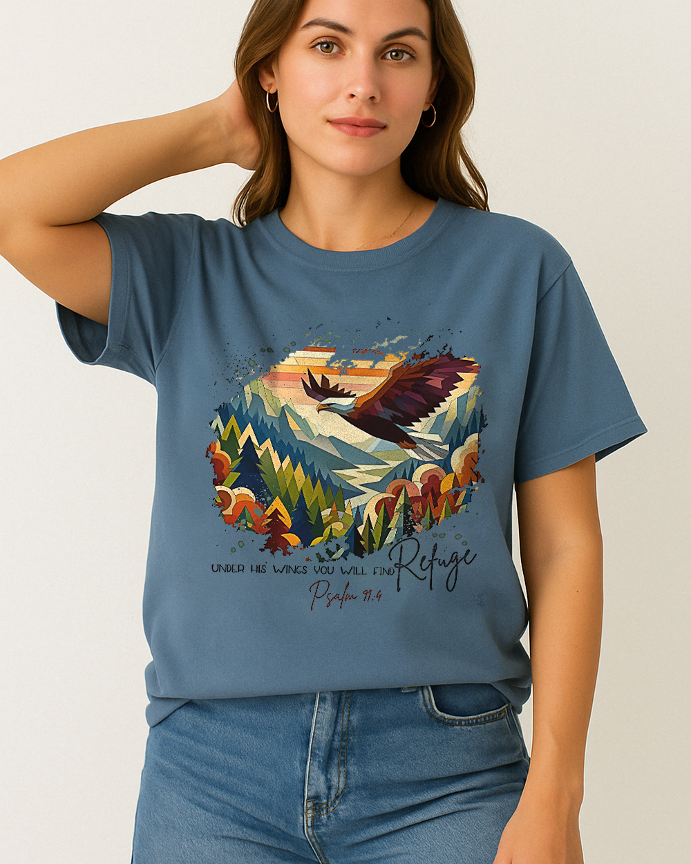 Blue Jean Comfort Colors shirt featuring “Under His Wings You Will Find Refuge” and vibrant eagle design. Styled casually with denim.