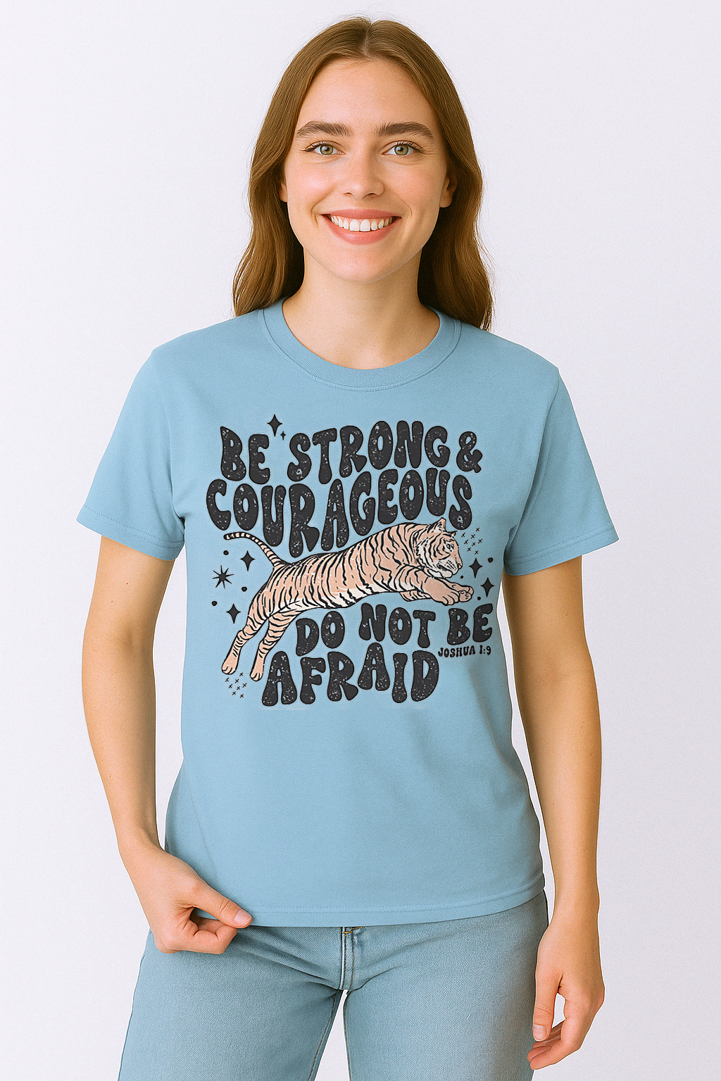 Chambray blue Comfort Colors shirt with Joshua 1:9 lettering and jumping tiger design. Worn casually with jeans and confidence.