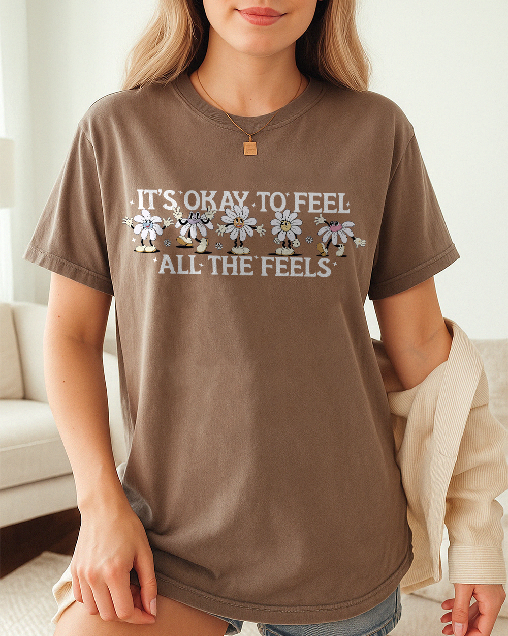 Blossom pink Comfort Colors shirt with playful daisy character design and “It’s Okay To Feel All The Feels” quote