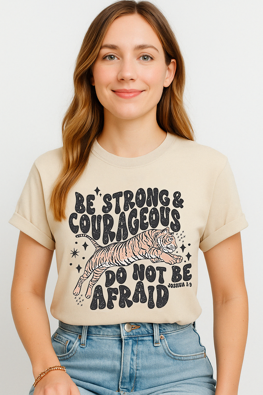 Ivory Comfort Colors 1717 shirt featuring bold tiger and faith quote from Joshua 1:9. Modeled by smiling woman in natural light.