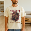Man modeling ivory “Strength Through Him” Christian shirt inside living room