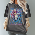 Relaxed-fit pepper color t-shirt styled casually with faith message “Greater Is He” and artistic lion face – Christian streetwear look.