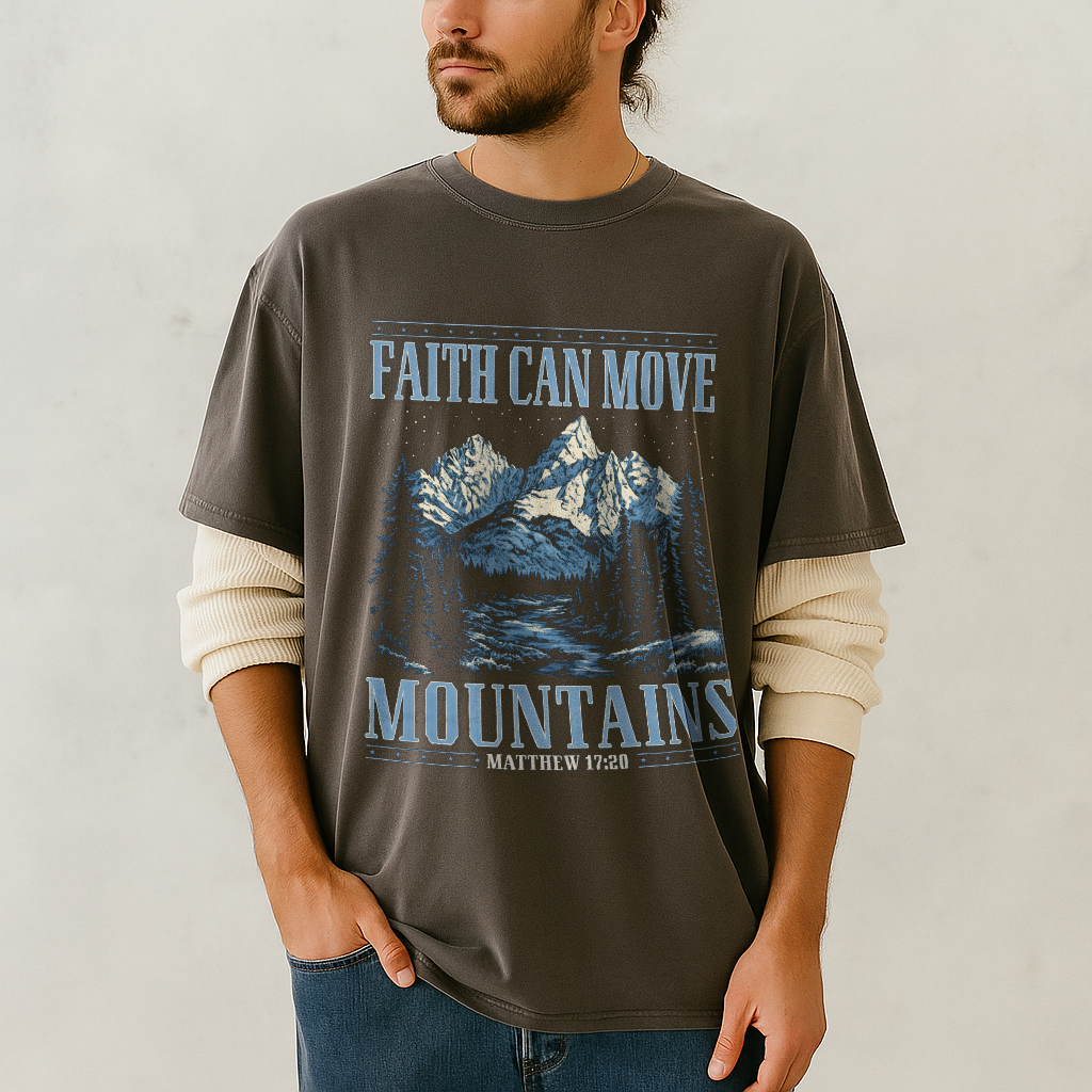 Man in dark grey (pepper) Comfort Colors shirt with Matthew 17:20 mountain print