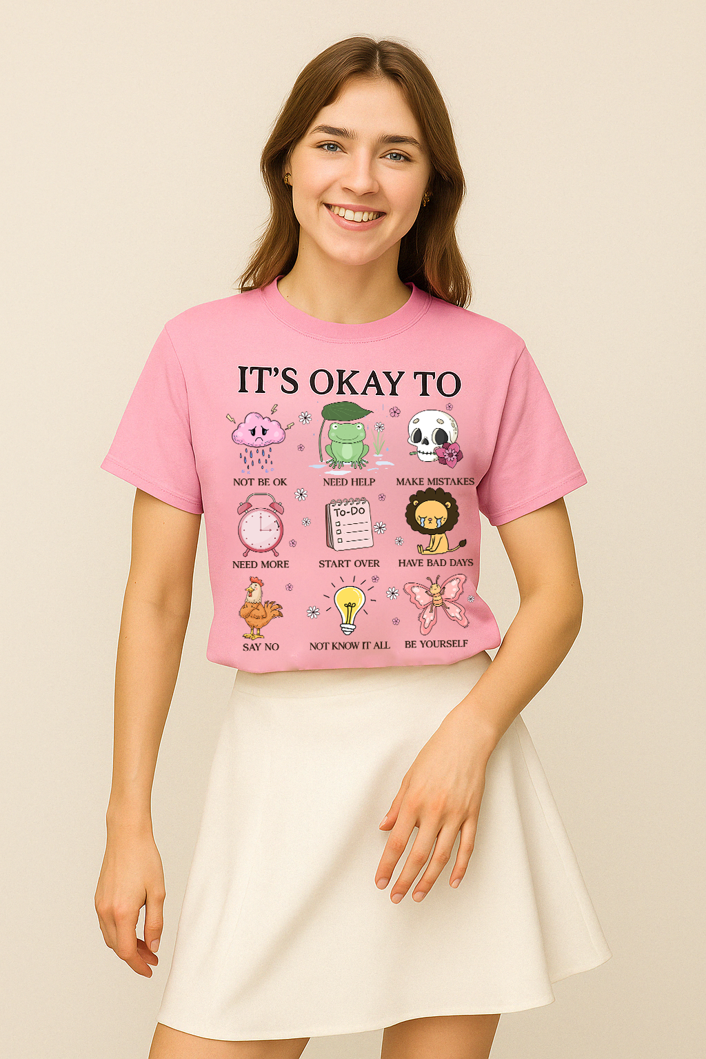 Blossom pink Comfort Colors 1717 shirt featuring “It’s Okay To Not Be Okay” and character illustrations. Worn with light styling.
